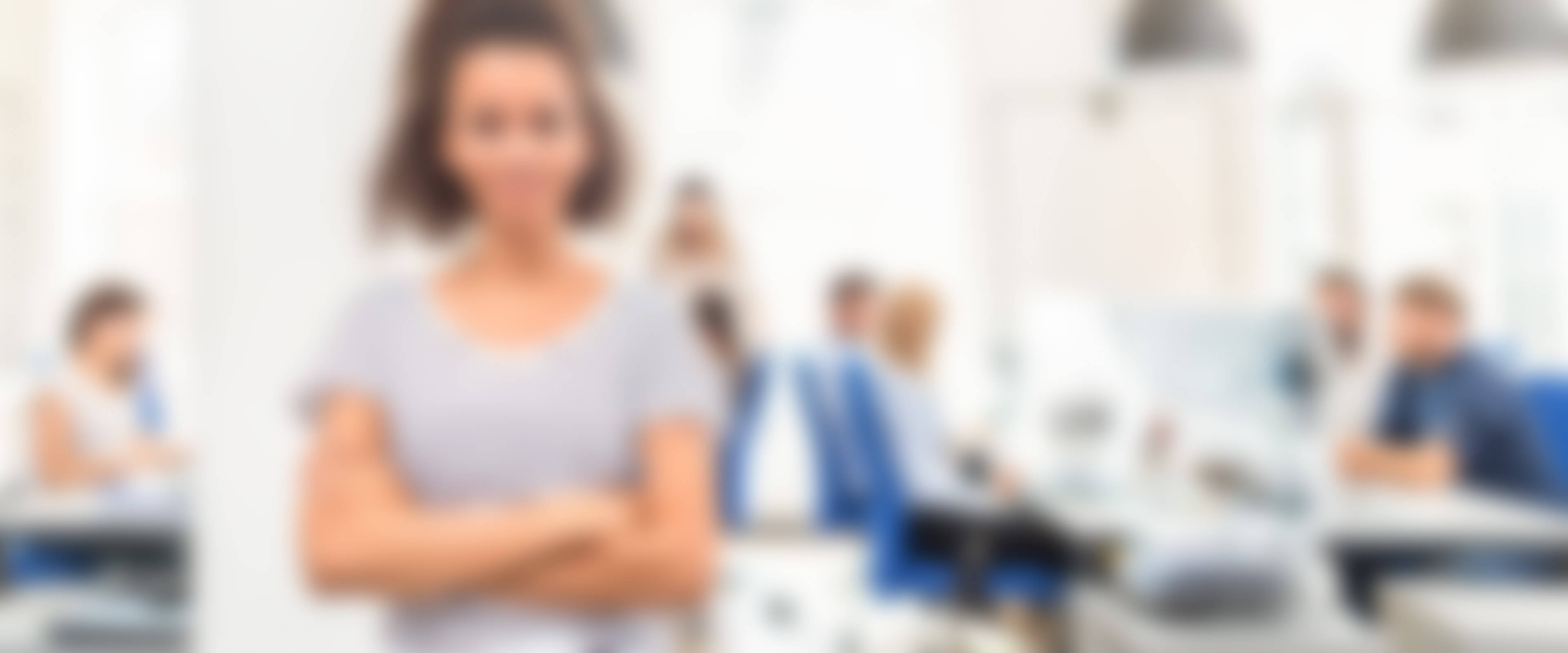 Mitarbeiterin steht in einem Großraumbüro